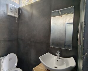 Ein Badezimmer mit Toilette, Waschbecken und einem Spiegel an der Wand.