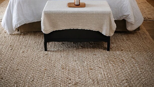 A bedroom with a stone wall, a wooden ceiling, a bed with white bedding, two bedside lamps, and a bedside table with a candle. - Le Cottage des Chalands (Saint-Georges-sur-Cher)