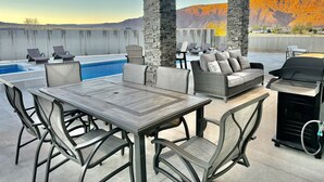 Eine Außenpatio mit Pool, Sitzgelegenheiten und Grillplatz.