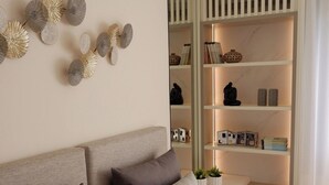 Een moderne slaapkamer met een groot bed, een nachtkastje en een ingebouwde boekenkast met planken.