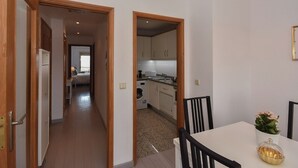 A modern apartment with a dining area, kitchen, and a hallway leading to a bedroom. - Porto Gaia River View (Vila Nova de Gaia)