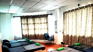 A room with multiple beds, a chair, and curtains. - OYO HOME 90768 Flo Inn Motel (Tawau)