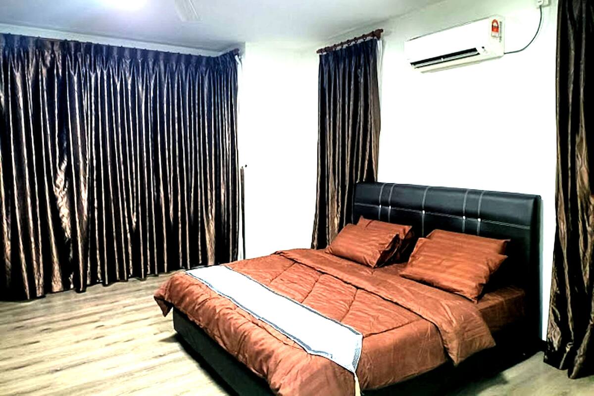 A bedroom with a bed, curtains, an air conditioning unit, and a ceiling fan.