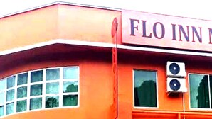 The exterior of Flo Inn Motel with a prominent sign, large windows, and air conditioning units. - OYO HOME 90768 Flo Inn Motel (Tawau)
