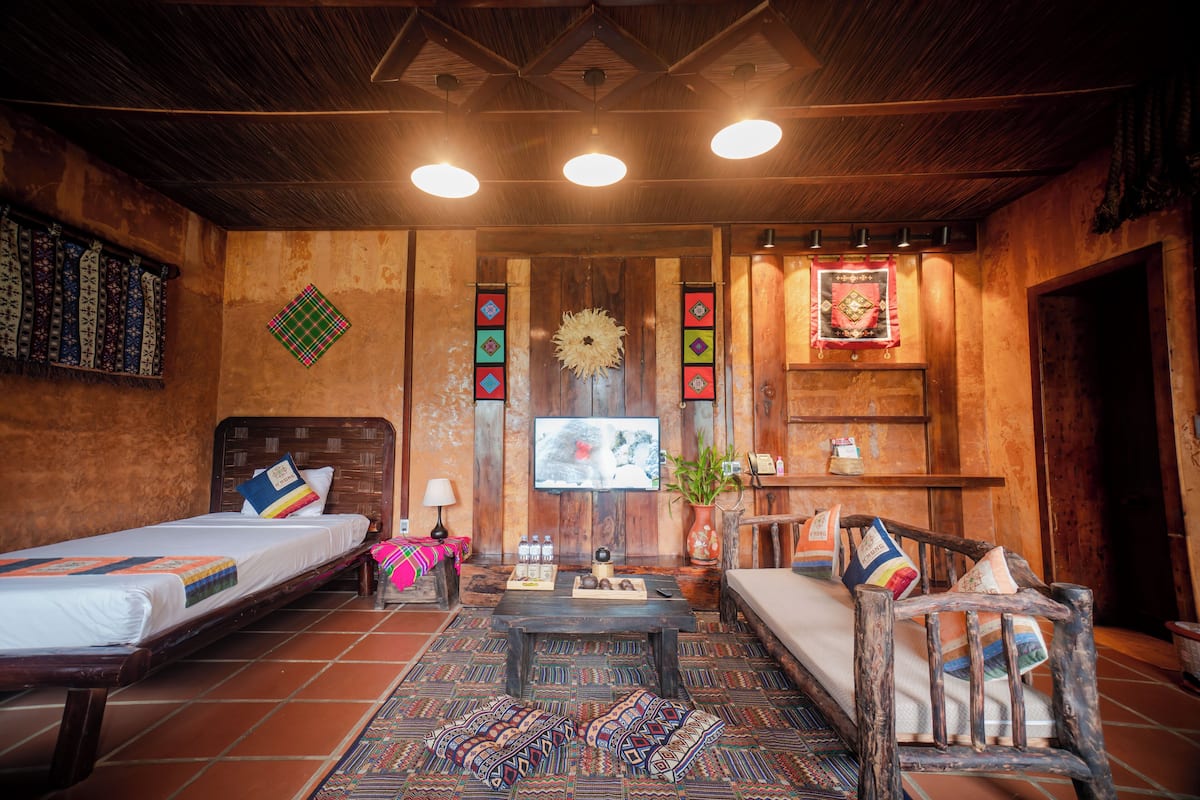 A cozy room with two beds, a wooden coffee table, and a TV.