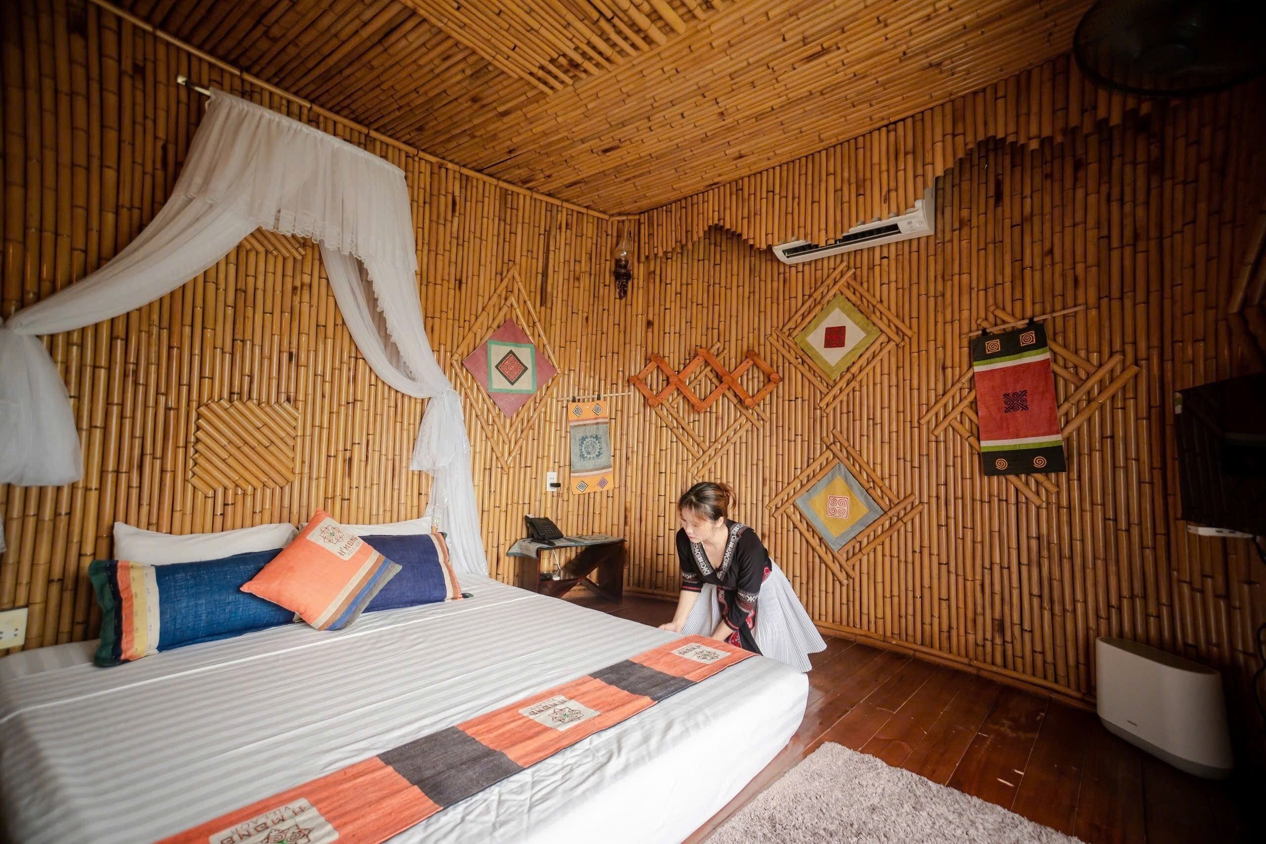 A room with a bed, a desk, and a wall decorated with geometric patterns.