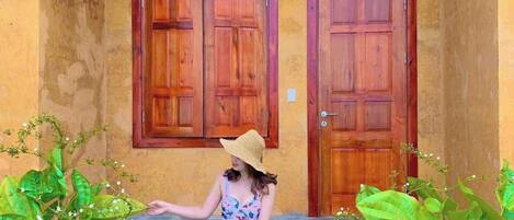 A person standing on stone steps in front of two wooden doors with a light fixture above.