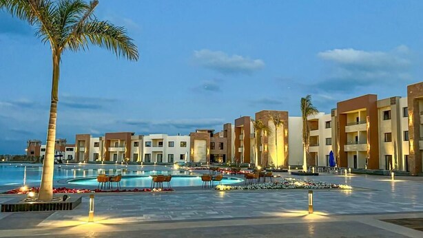 A hotel with multiple swimming pools, palm trees, and modern architecture. - Helnan Hotel Port Fouad (Port Fuad)