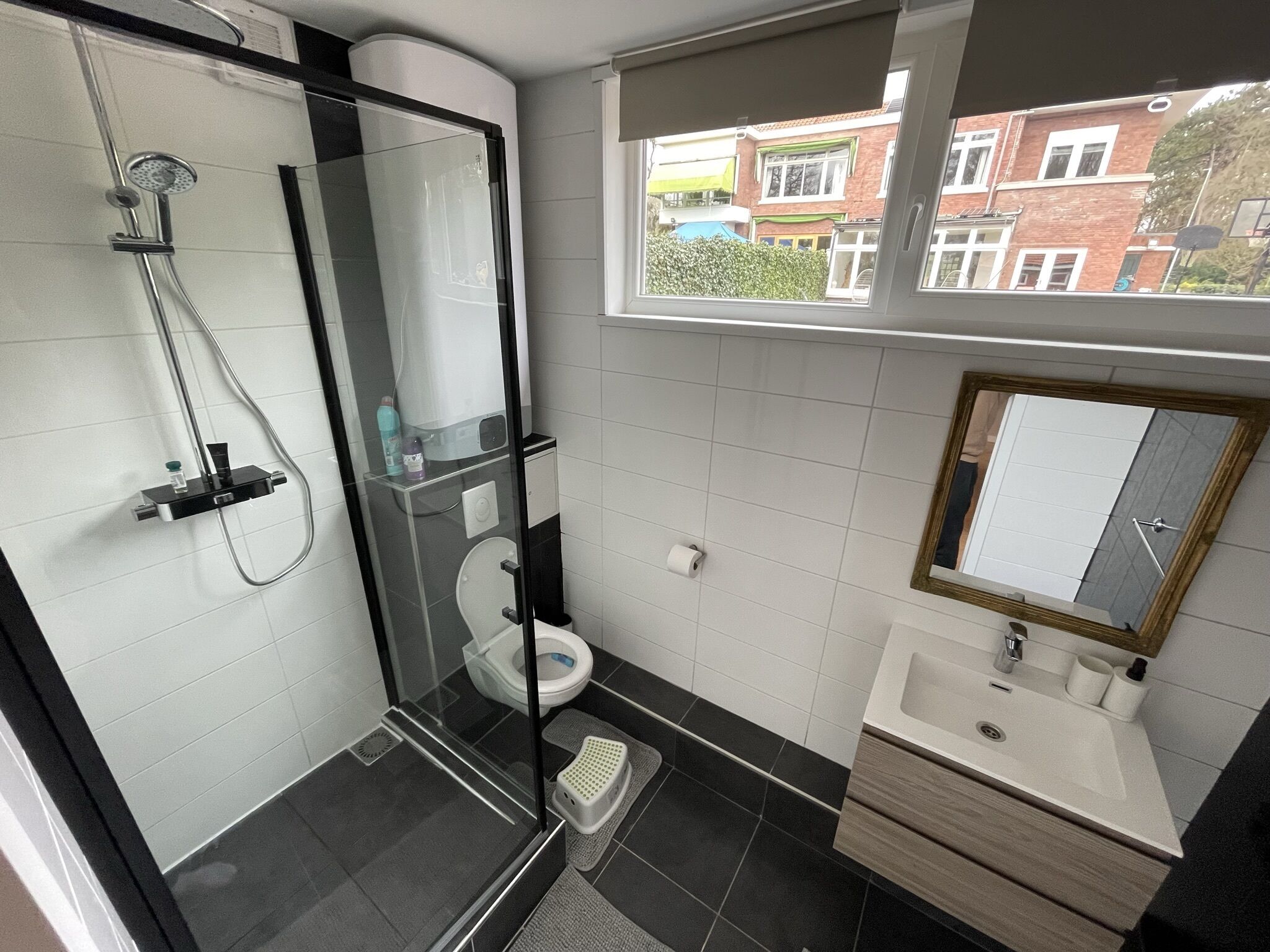 Une salle de bain moderne avec une douche à parois de verre, des toilettes et un lavabo avec un miroir.