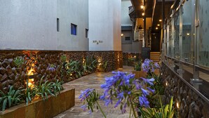 A corridor with a stone wall on one side and a glass railing on the other, leading to a staircase. - Saggys Suites Hotel & Spa (Nairobi)
