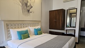 Habitación de hotel ordenada con cama, mesita de noche, armario y espejo.