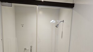 Un baño moderno con ducha de vidrio, inodoro y bañera.