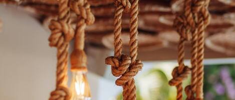 A rustic ceiling with exposed wooden beams and ropes.