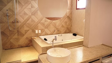 Un baño moderno con una bañera independiente, un espejo redondo y un lavabo con recipiente.