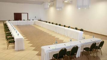 Ein Konferenzraum mit einem langen Tisch, Stühlen und Wasserflaschen.