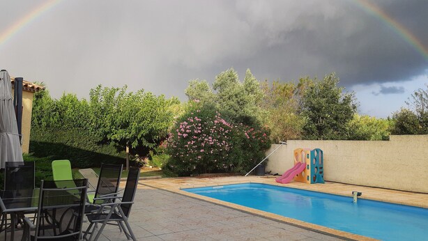 A backyard with a swimming pool, a slide, and a table with chairs. - LOFT 100m2 (Aubord)