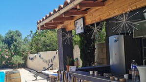 An outdoor bar area with a pool, wooden pergola, and stone wall. - LOFT 100m2 (Aubord)
