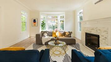 A living room with a sofa, a coffee table, and a fireplace.