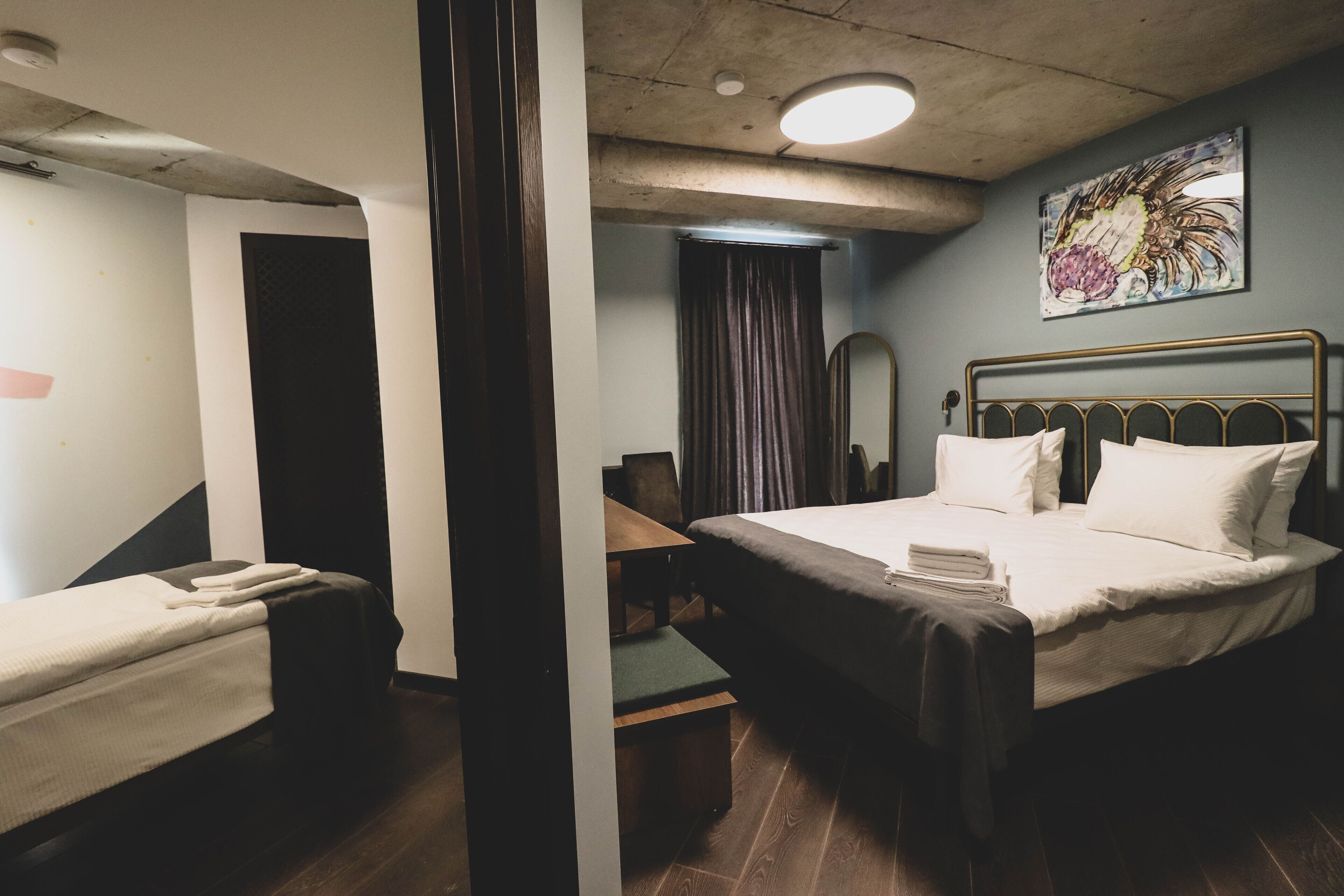 A hotel room with a bed, a desk, a chair, and a bathroom.