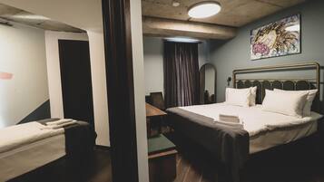 A hotel room with a bed, a desk, a chair, and a bathroom.