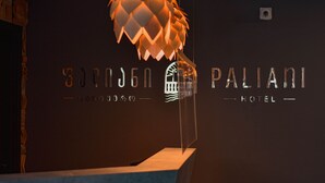 A hotel reception area with a unique hanging light fixture and a clear view of the hotel name 'Pallani' on the wall. - Paliani Hotel (Mestia)