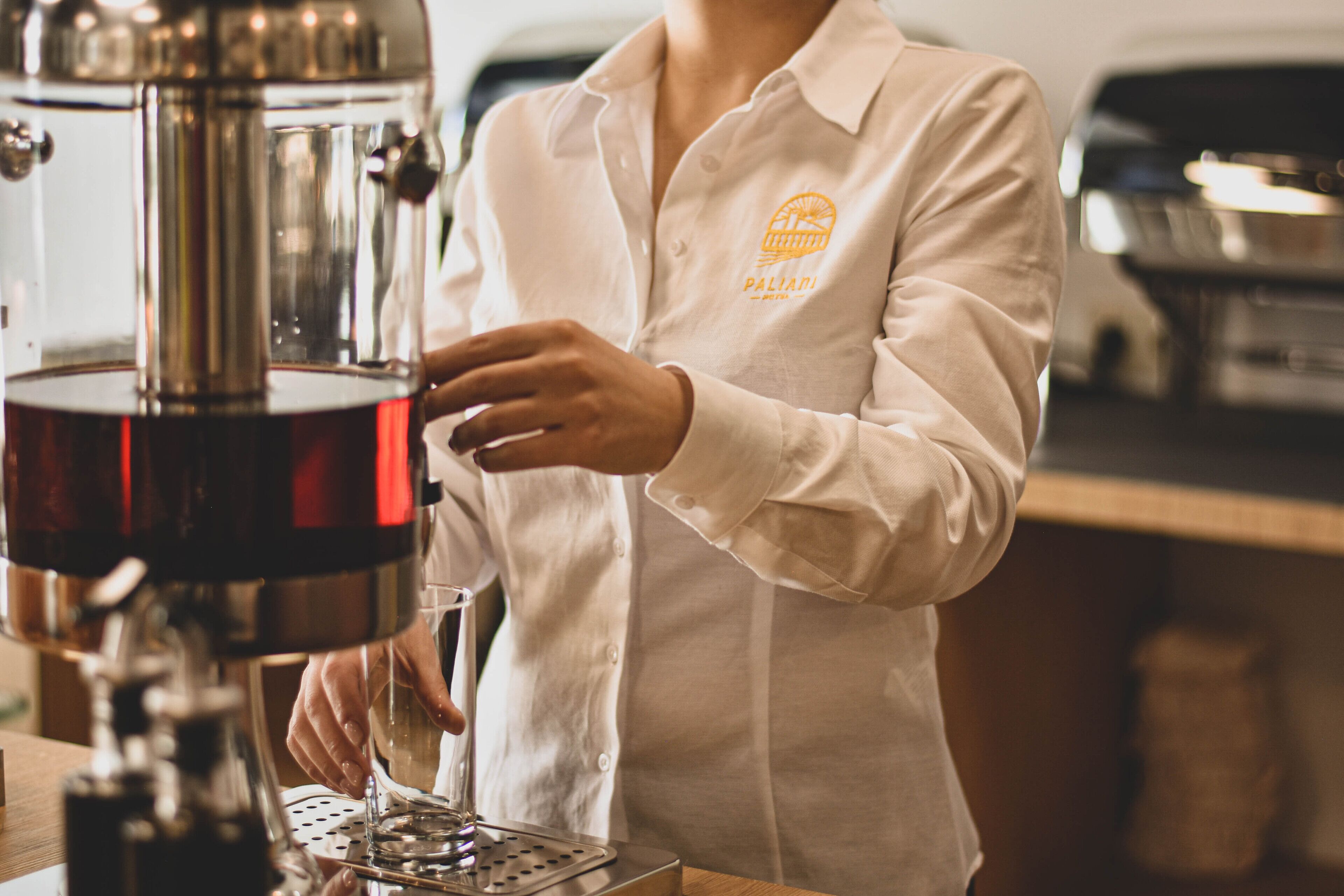 Una persona usando una cafetera en una cocina.