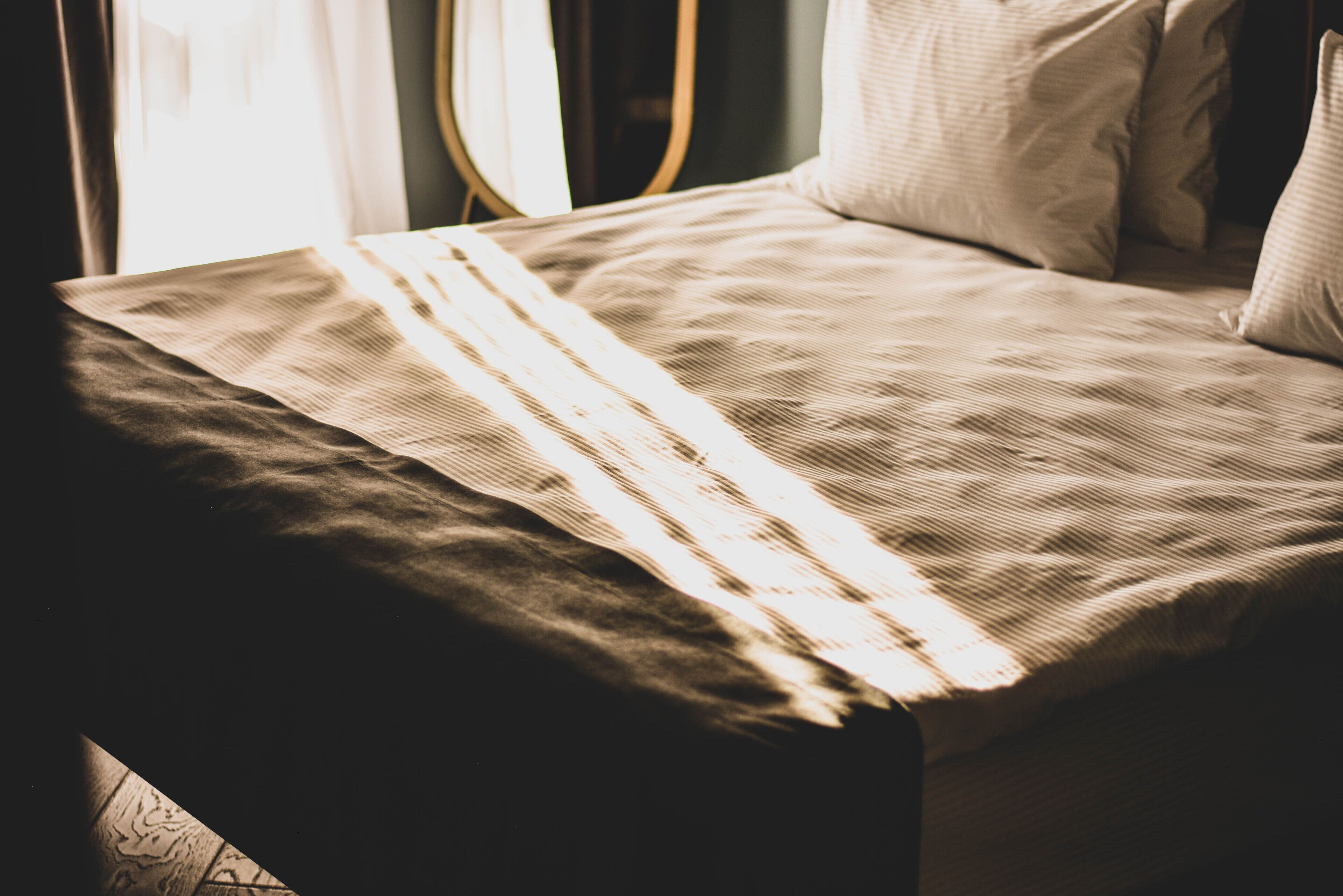 Un lit avec une couvre-lit à rayures et des oreillers.