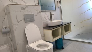 Een douche, een haardroger, een bidet, handdoeken