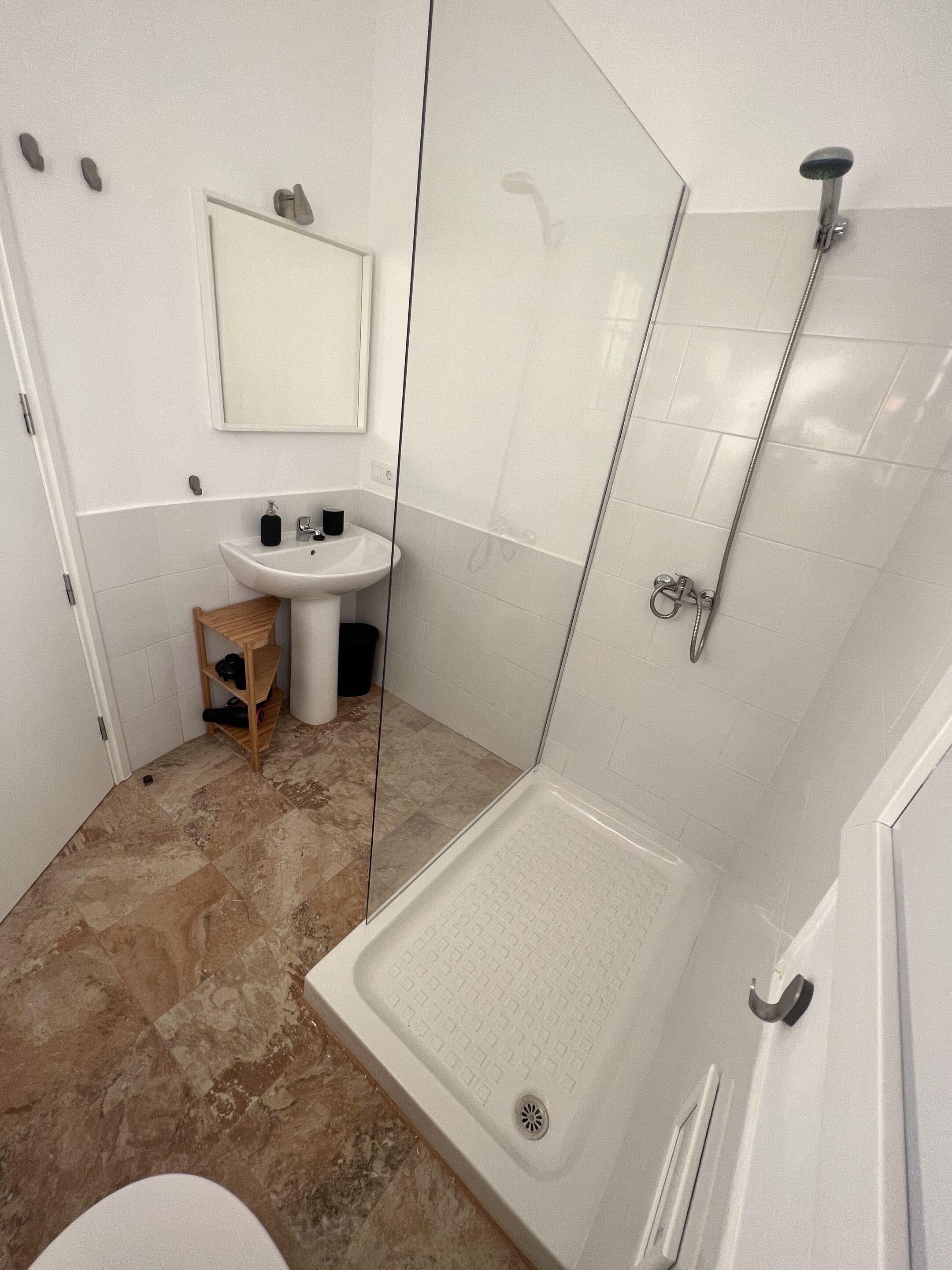 A bathroom with a shower, sink, and toilet.