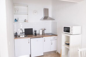 Cafetera o tetera, frigorífico, microondas y placa de cocina