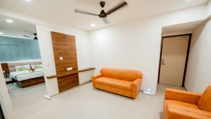 Una sala moderna con sofá, un muro decorativo de madera y un ventilador de techo.