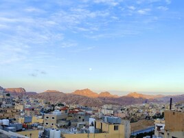 A cityscape with buildings and mountains in the background.