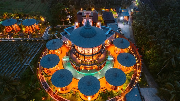 A circular building with a central dome and surrounding structures, surrounded by a landscaped garden. - Hotel Le Temple (Borobudur)