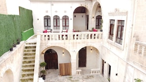 Stunning courtyard with arched doorways and windows, surrounded by a stone balustrade.