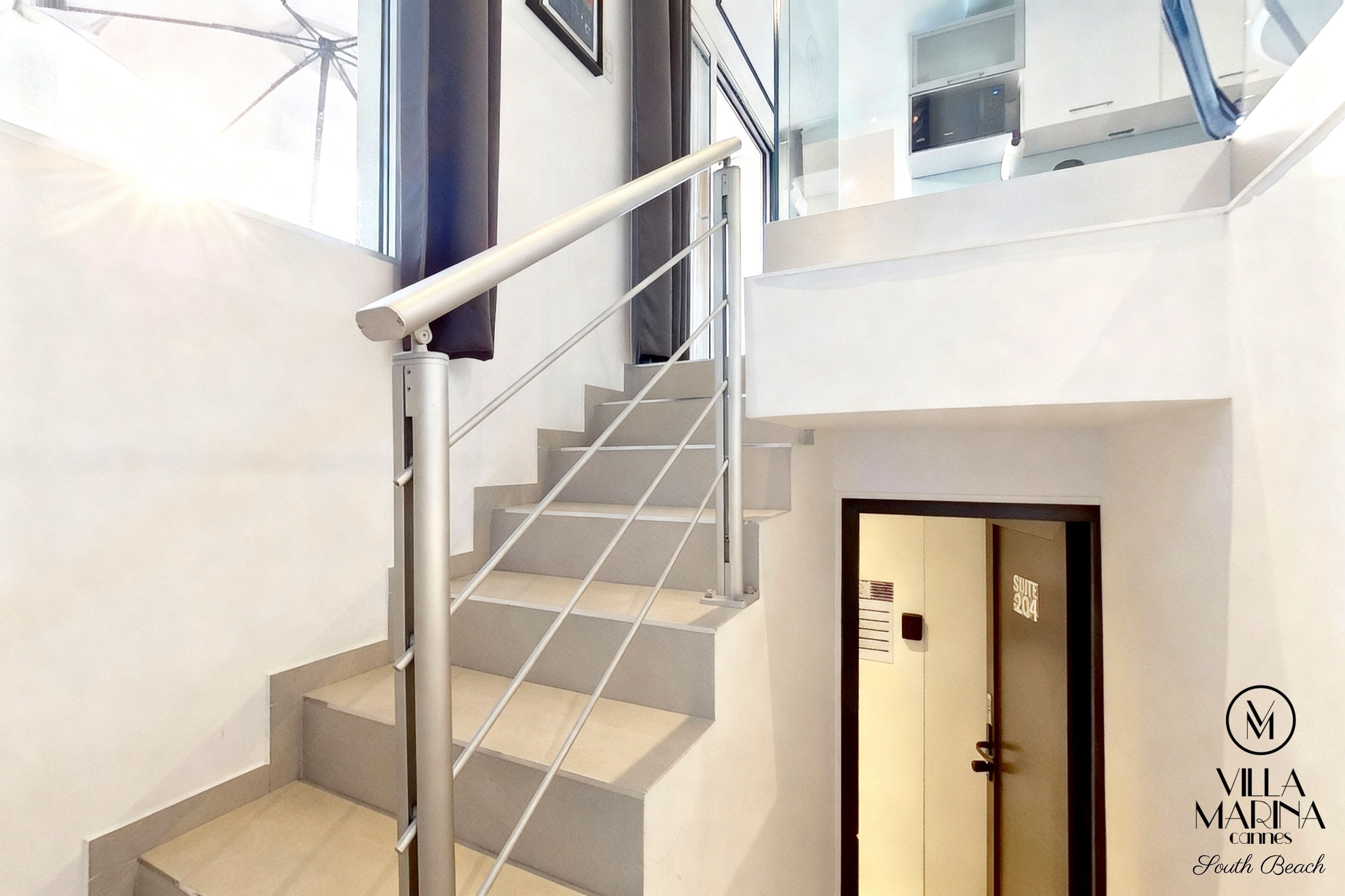En moderne trappe med gelænder i metal, der fører op til en dør med teksten "Suite 304".