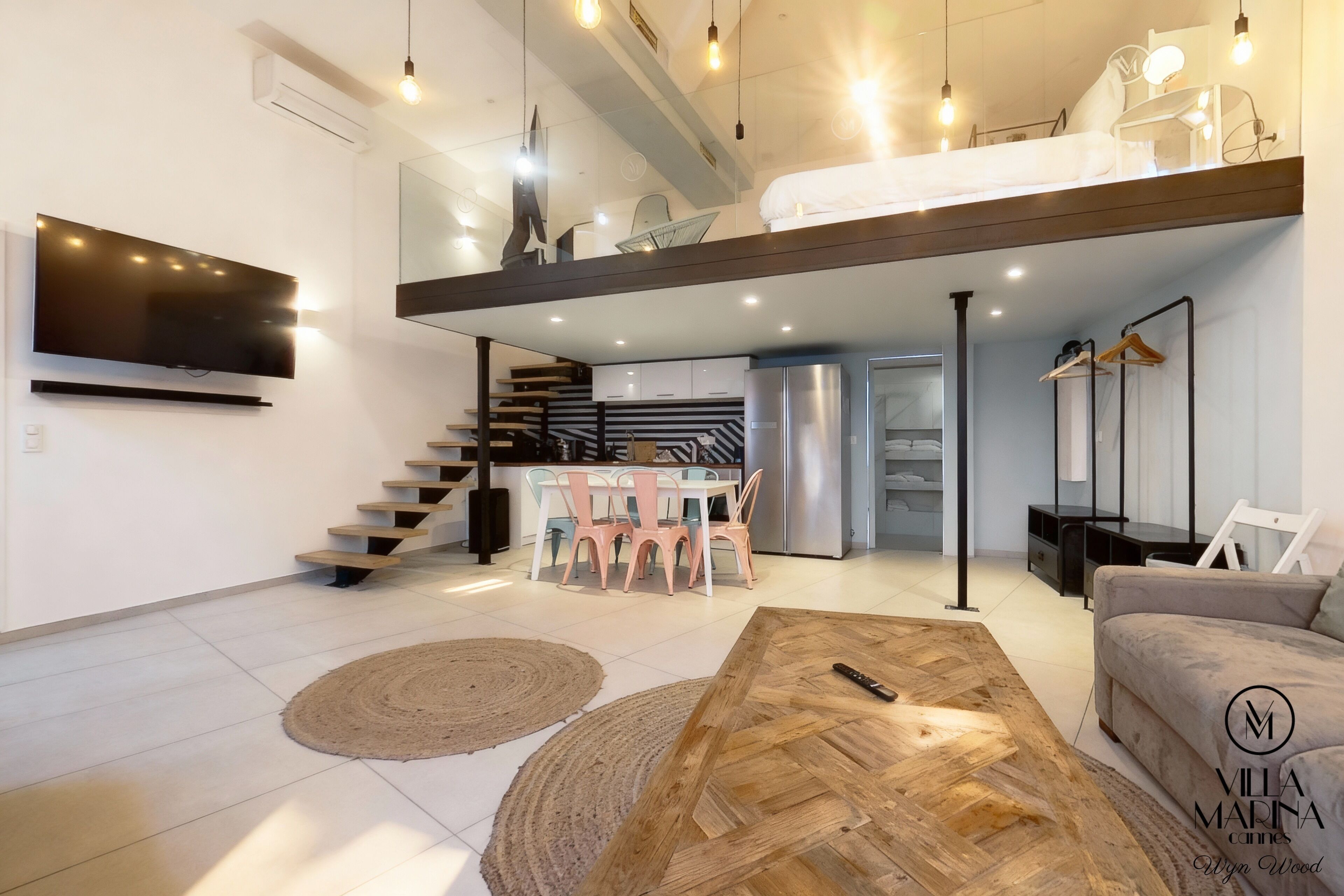 Un espacio habitable moderno con habitación tipo loft, cocina y comedor.