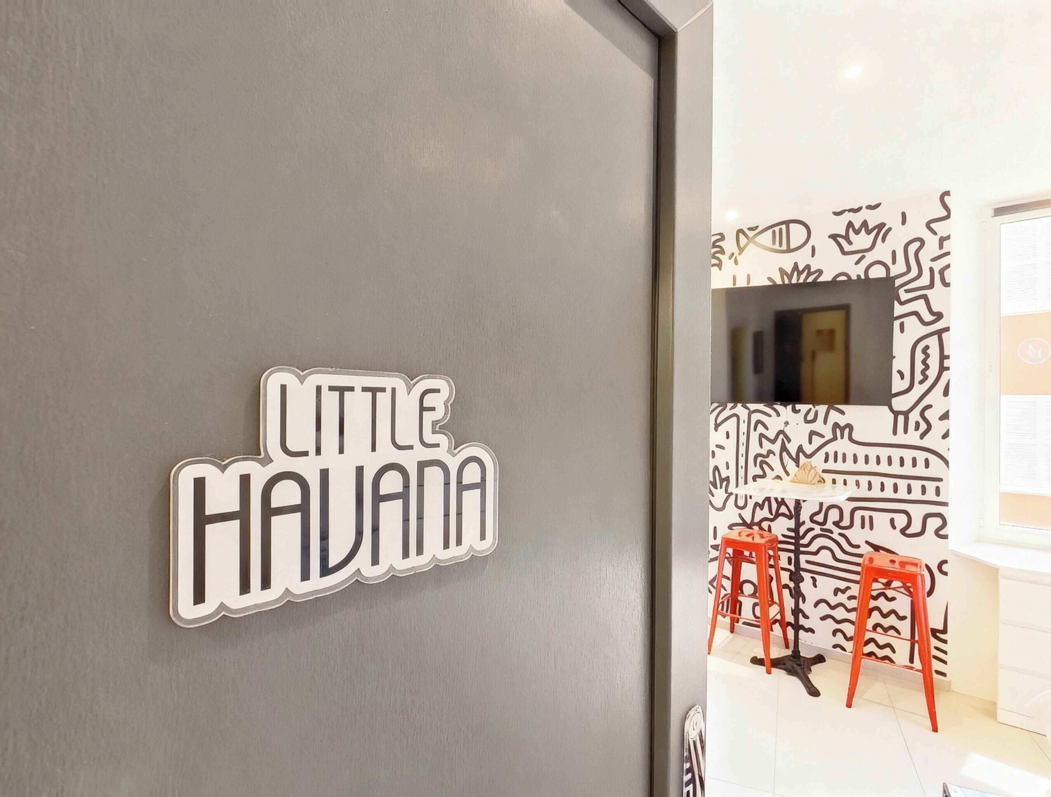 Ein Schild mit der Aufschrift 'LITTLE HAVANA' an einer Wand.
