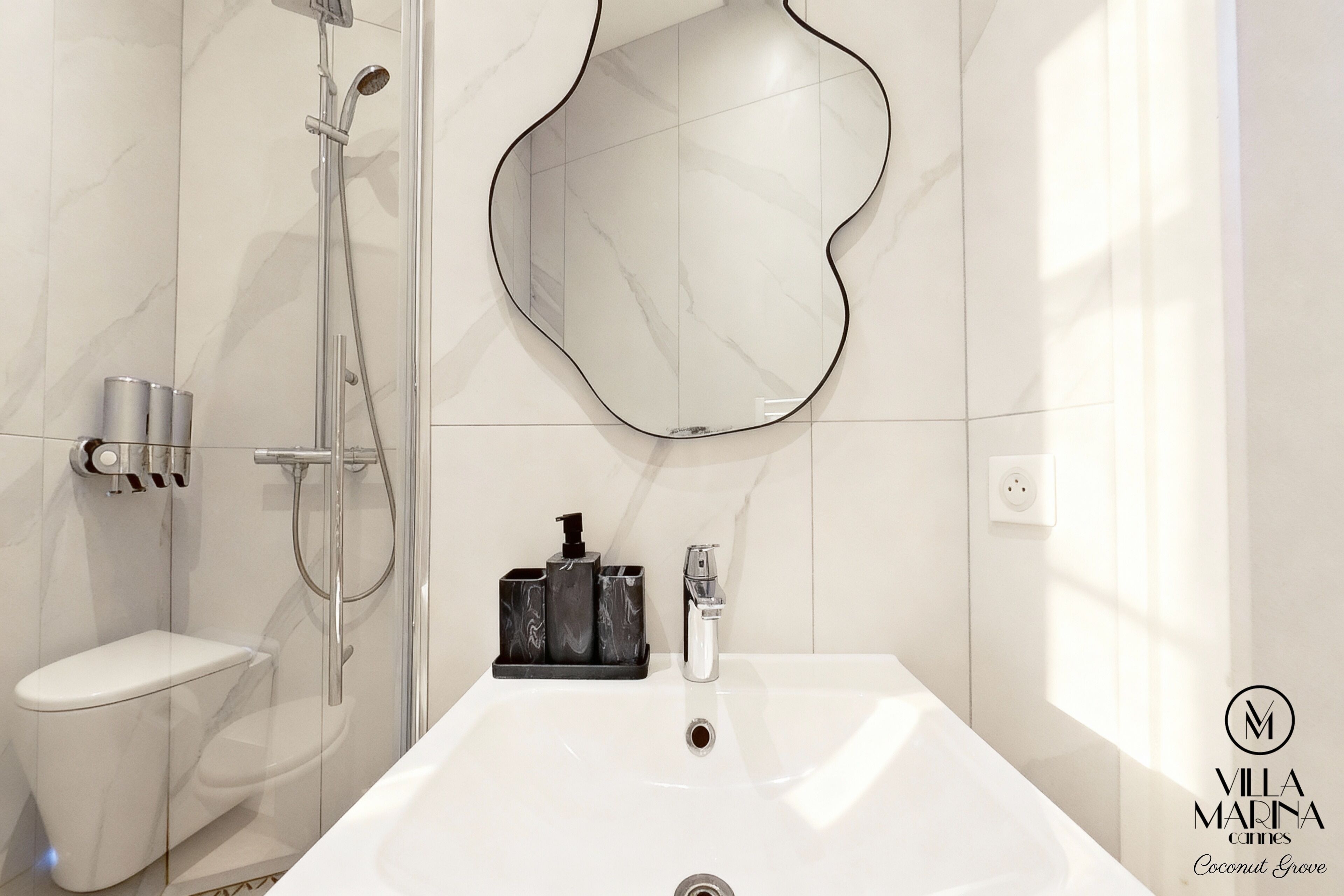 A modern bathroom with a toilet, a shower, and a sink.