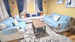 Una sala de estar con dos sofás, una mesa de centro y una alfombra estampada.