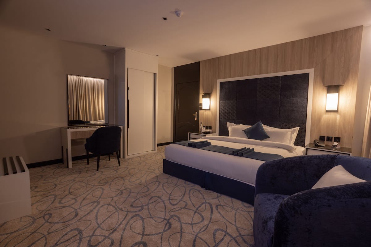 Ein Hotelzimmer mit einem großen Bett, einem Schreibtisch und einem Stuhl.