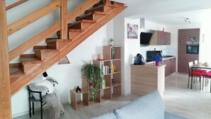 A modern kitchen with wooden cabinets, a built-in oven, and a dining area with a table and chairs. - Comfortable rarounette gite in the heart of the Vosges mountains (celles sur plaine)