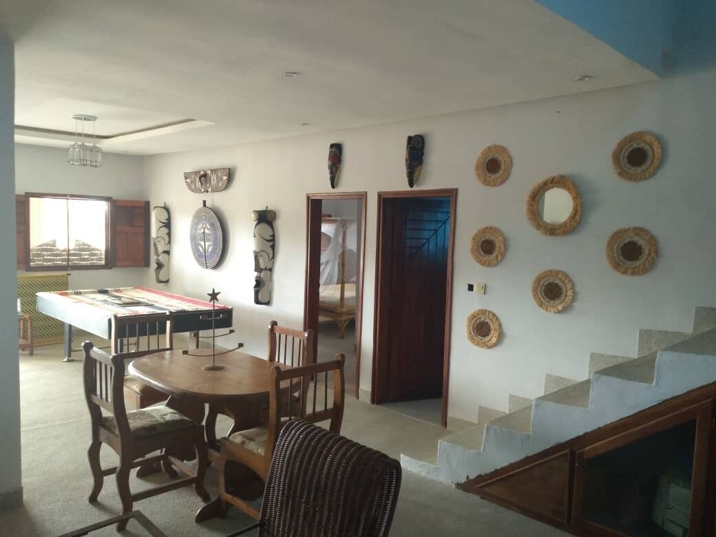 A dining area with a table and chairs, a staircase, and decorative wall art.