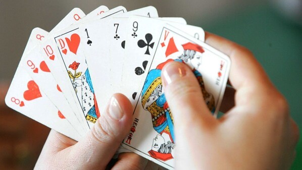 A hand holding a deck of playing cards. - Résidence LE MARLODJ (Fatick)