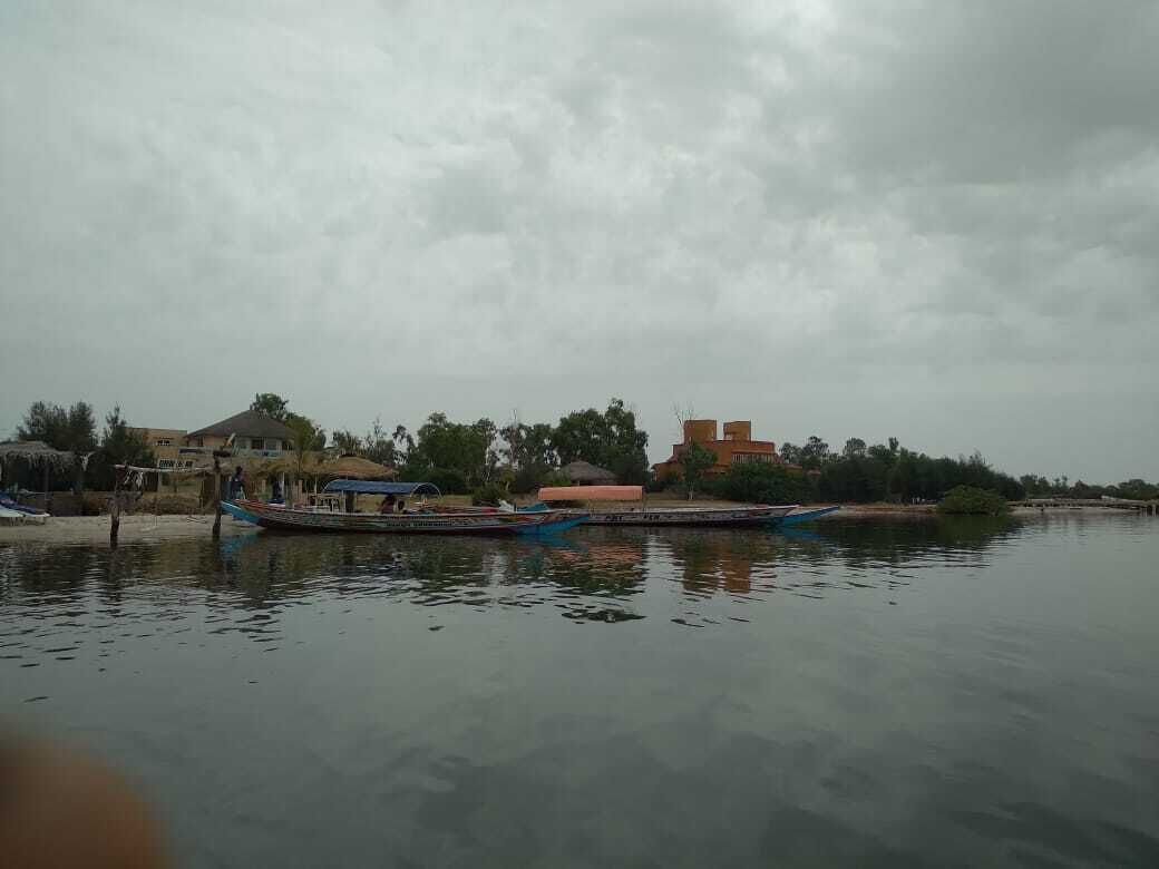 Une rivière paisible, bordée de bateaux et de bâtiments.