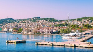 A coastal marina with docked yachts, a pier, and a densely built hillside town in the background. - Argostoli Essence Suites (Kefalonia)