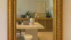 A large ornate gold-framed mirror with a table and chairs in front. - Argostoli Essence Suites (Kefalonia)