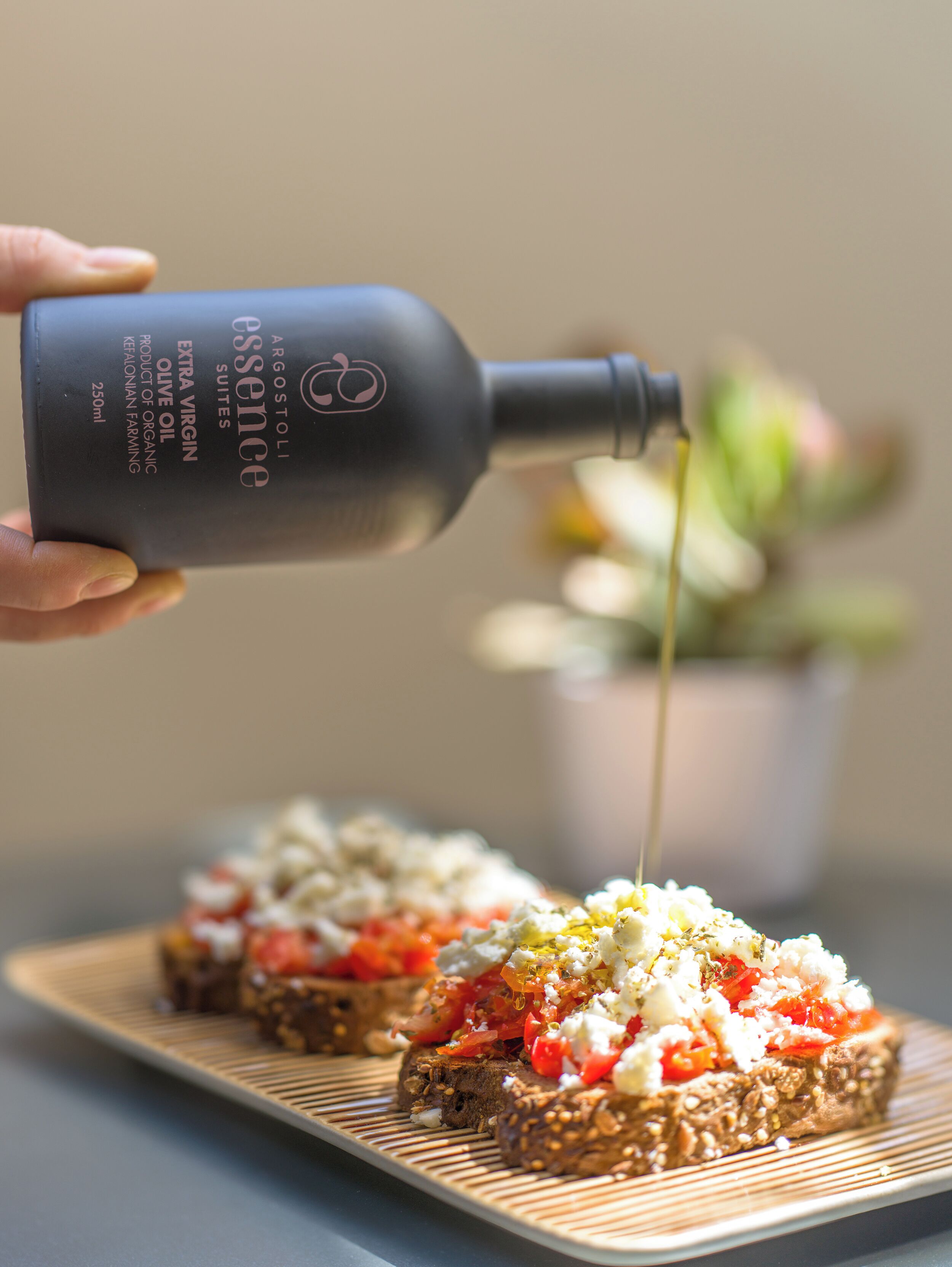 Se vierte aceite de oliva extra virgen sobre una tabla de madera con una rebanada de pan cubierta de tomates y queso.