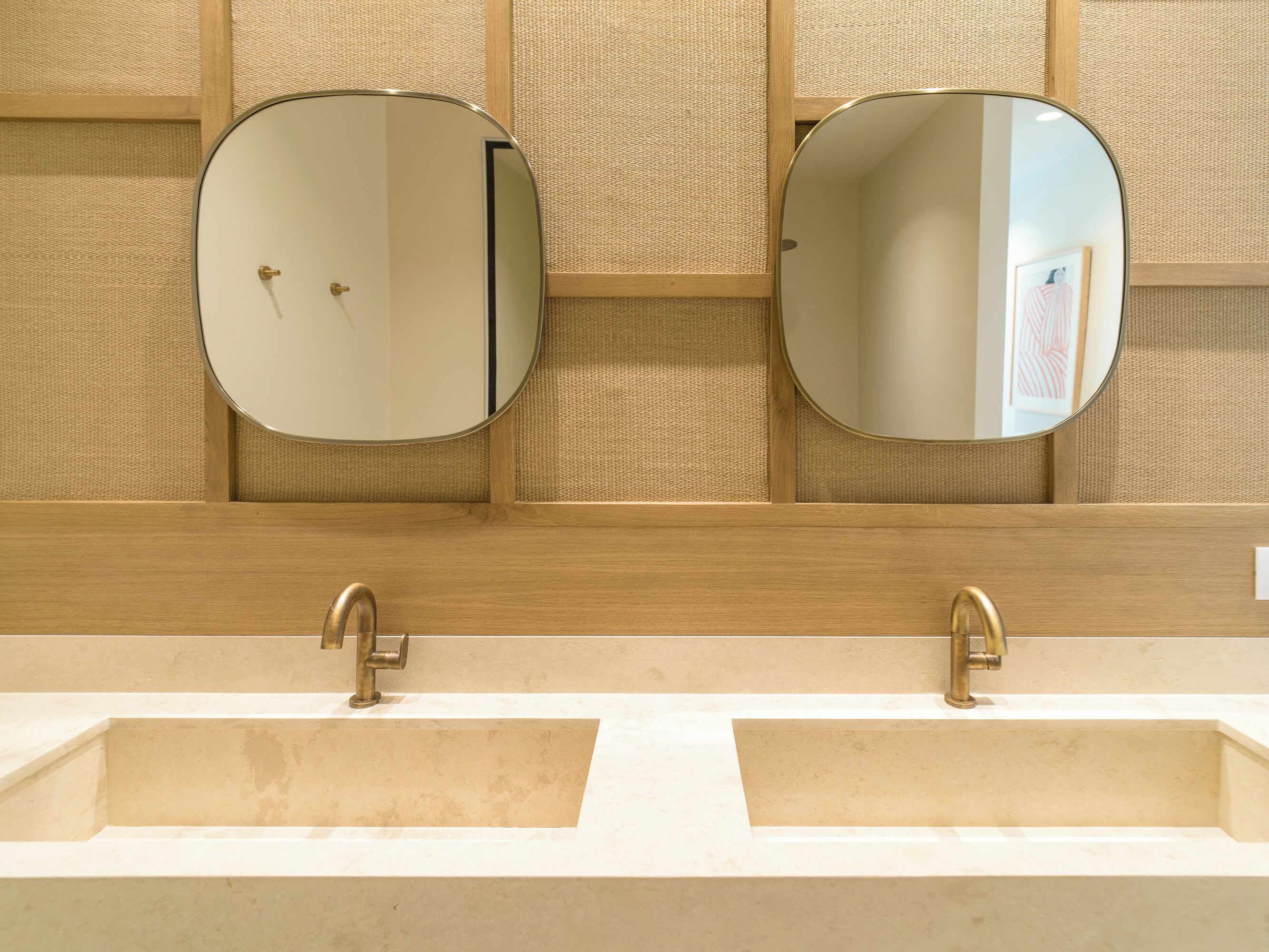 A bathroom with two sinks, each with a round mirror above.