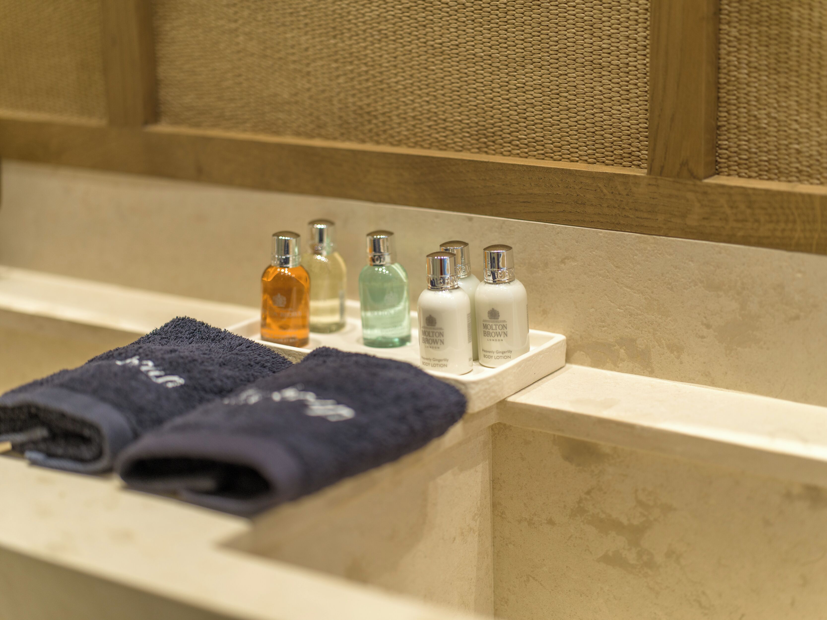 Une salle de bain avec une étagère où sont rangés les articles de toilette et les serviettes.