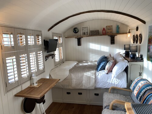 Luxury heated shepherd's hut in field location.